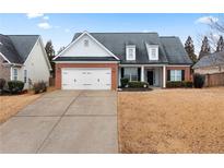 Brick and white two-story house with a two-car garage and landscaping at 23 Spring Folly Nw, Cartersville, GA 30121