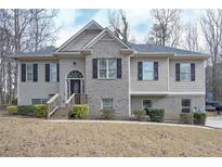 Two-story house with gray siding, brick accents, and a covered porch at 6982 Springwood Dr, Douglasville, GA 30135