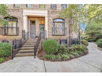 Brick townhouse with steps, wrought iron railings, and landscaping at 3633 Habersham Rd, Atlanta, GA 30305