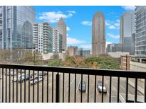 Condo balcony view overlooking the cityscape with parking and surrounding buildings in the background at 1075 Peachtree Ne Walk # A421, Atlanta, GA 30309