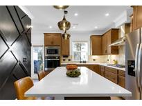 Modern kitchen featuring a sleek island, stainless steel appliances, and stylish light fixtures at 2505 Astaire Nw Ct, Atlanta, GA 30318