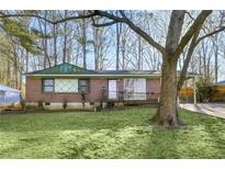 Brick ranch house with carport, large yard, and mature trees at 4488 Richard Rd, Conley, GA 30288