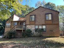 Two-story house with wood siding, stone accents, and a deck at 3763 Woodrose Ct, Snellville, GA 30039