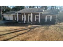 Brick ranch house with attached garage and front porch at 1850 Cashmere Ct, Lithonia, GA 30058