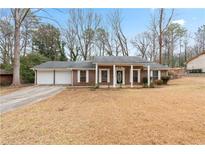 Charming single-story brick home featuring a welcoming front porch and a two-car garage at 1850 Cashmere Ct, Lithonia, GA 30058