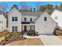 Charming two-story home with white siding, a two-car garage, and well-maintained landscaping at 2865 Ferncliff St, Cumming, GA 30028