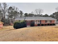 Brick ranch house with mature trees and a spacious yard at 879 Old Tucker Rd, Stone Mountain, GA 30087