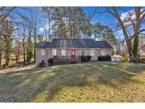 Gray house with red door, deck, and grassy yard at 1058 Hickory Rd, Canton, GA 30115