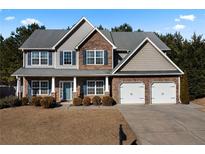 Two-story house with stone accents, two-car garage, and manicured lawn at 18 Ponders Se Rd, Cartersville, GA 30121