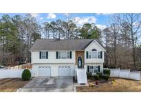 Two-story house with two-car garage, stone accents and a landscaped yard at 1620 Cedar Hl, Douglasville, GA 30134