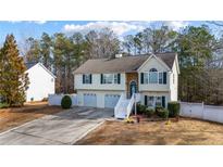 Charming two-story home with a two-car garage and a welcoming entrance with white stairs and a landscaped yard at 1620 Cedar Hl, Douglasville, GA 30134