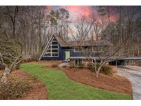 A-frame home with a modern exterior, landscaped lawn, and covered carport at 3894 Foxford Dr, Atlanta, GA 30340