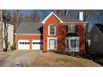 Brick house with two-car garage and landscaped lawn at 1495 Gabriel Dr, Lawrenceville, GA 30043