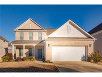 Two-story brick home with a large white garage door and landscaping at 5482 Fountainhead Ln, Auburn, GA 30011