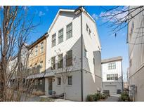 Three-story townhome with white siding, gray brick, and a small patio at 723 Perch Pl, Atlanta, GA 30312