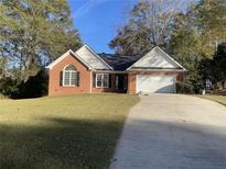 Brick ranch house with a driveway and landscaped lawn at 11564 Holly Ln, Hampton, GA 30228