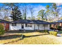 Charming ranch home with white exterior, black accents, and landscaped lawn at 2745 Fairlane Se Dr, Atlanta, GA 30354