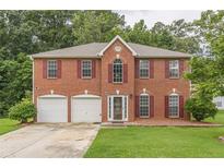 Brick two-story house with a two-car garage and a well-manicured lawn at 4332 Abram Dr, Conley, GA 30288