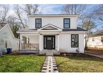Charming two-story home with white siding, black framed windows, a front porch, and a stone walkway at 1449 Athens Sw Ave, Atlanta, GA 30310