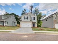 Charming two-story home featuring a brick-accented garage and manicured front lawn at 18 Camellia Dr, Fairburn, GA 30213