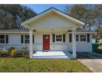 Charming single-story home featuring a bright red door, black shutters and a freshly painted porch at 5291 Lyndale Cir, Forest Park, GA 30297