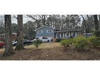 Ranch style home with gray siding, attached garage, and a spacious yard at 205 Dogwood Ln, Lawrenceville, GA 30046