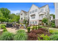 Beautiful two-story townhouse with a brick patio, fire pit, and outdoor seating surrounded by lush landscaping at 396 Silverbell Way, Marietta, GA 30060