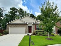 Brick home with 2-car garage, landscaping, and a welcoming front yard at 3909 Makeover Ct, Atlanta, GA 30349