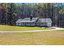 Charming ranch-style home with a welcoming porch and beautiful, expansive front lawn at 239 Cedar Ridge Dr, Dallas, GA 30157