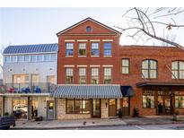 Brick building with a metal roof and storefront at 9057 Selborne Ln, Chattahoochee Hills, GA 30268