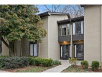 Tan colored exterior of a townhome with manicured landscaping and walkway at 16 Ivy Ne Rdg, Atlanta, GA 30342
