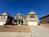 Two-story brick home with a three-car garage and landscaped yard at 3421 Andover Way, Buford, GA 30519