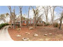Brick house with mature trees and a long driveway at 790 Oakhaven Dr, Roswell, GA 30075