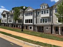 Beautiful townhome with a classic exterior design featuring a black fence and manicured front lawn at 1980 Flying Scotsman Dr # 10, Kennesaw, GA 30144