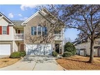 Brick front townhouse with two-story elevation, attached garage, and manicured landscaping at 4658 Grand Central Pkwy, Decatur, GA 30035