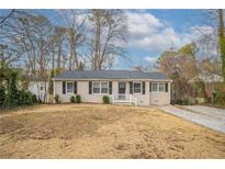 Charming single story home with manicured front yard and walkway to front door at 3234 Bluebird Ln, Decatur, GA 30032