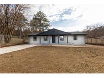 Charming single-story home featuring a painted brick facade, a covered entryway, and a well-maintained front yard at 935 Conley Road Southeast Se Rd, Atlanta, GA 30354