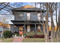 Two-story house featuring a gray exterior, wraparound porch, and landscaped yard at 679 N Central Ave, Hapeville, GA 30354