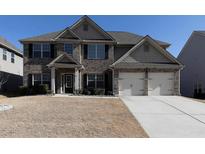 Brick two-story house with a three-car garage and well-maintained lawn at 325 Allgood Trce, Acworth, GA 30101