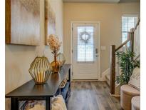 Inviting entryway features stylish decor, a console table, and durable wood-look flooring leading to the front door and stairs at 130 Bingley Ct, Covington, GA 30016