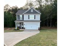 Charming two-story home with a two-car garage and well-manicured lawn at 130 Bingley Ct, Covington, GA 30016
