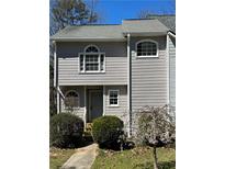 Charming exterior featuring neutral siding, arched windows, and lush landscaping, creating a welcoming curb appeal at 1699 Paddlewheel Dr, Marietta, GA 30062