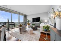 Bright living room with hardwood floors, city views, and stylish furnishings at 1080 Peachtree Ne St # 3309, Atlanta, GA 30309