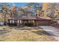 Cozy ranch-style home with a wooded front yard and a charming covered porch entry at 175 Highland Cir, Mcdonough, GA 30253