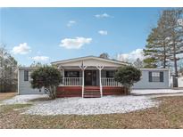 Ranch-style home with covered porch and landscaped yard at 1265 Glenbrooke Cv, Lawrenceville, GA 30045