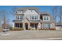 Two-story brick home with a metal roof and landscaped yard at 5015 Montes Ln, Cumming, GA 30040