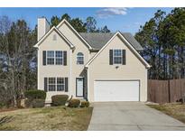 Two-story house with attached garage and landscaped yard at 6738 Merrywood Dr, Fairburn, GA 30213