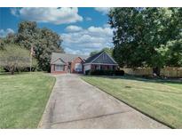 Brick ranch home with a large front yard and driveway at 1809 Francon Sw Ct, Conyers, GA 30094