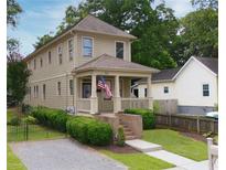 Charming two-story home with a welcoming front porch, an American flag, and well-maintained landscaping at 301 Fortune Ne St, Atlanta, GA 30312