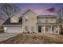 Two-story house featuring a neutral exterior, a large driveway, and landscaping at 537 N Cedar N Ct, Riverdale, GA 30274